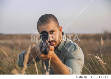 shooter aim in the field with a sniper rifle 100915949