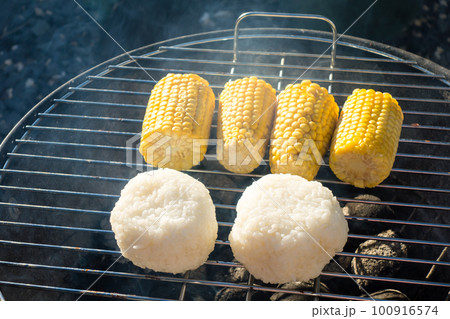 バーベキューセットの炭で焼くトウモロコシと焼きおにぎり 100916574
