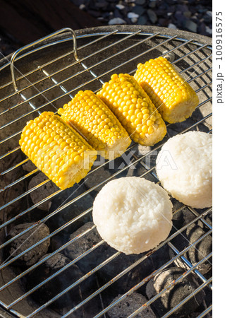 バーベキューセットの炭で焼くトウモロコシと焼きおにぎり バーベキューセットの炭で焼くトウモロコシと焼きおにぎり 100916575