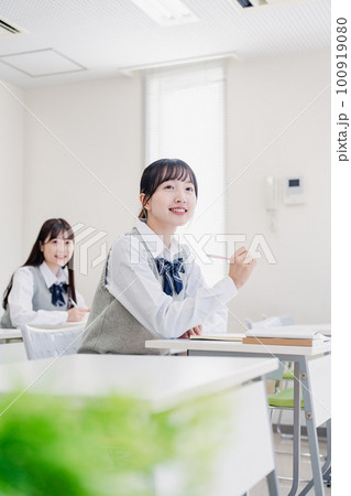 手を上げて発表をする女子高生 100919080