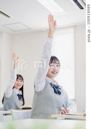 手を上げて発表をする女子高生 100919089