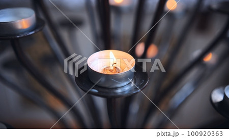 Candlestick holder with burning candles in a Catholic church. 100920363