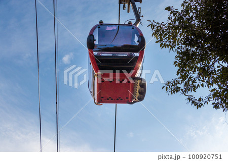 ロープウェイの赤いゴンドラと青い空 100920751