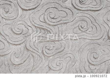 Low relief cement Chinese style handcraft of clouds. Abstract stone background. Close up beautiful traditional grey wall background with cloud shape 100921072