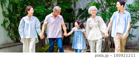 手をつないで庭を歩く三世代家族 手をつないで庭を歩く三世代家族 100921211