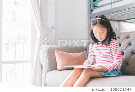 cute girl paint or do homework on sofa in living room, learn and relax cute girl paint or do homework on sofa in living room, learn and relax 100921647
