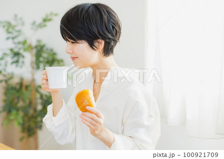 朝食を食べる若い女性　 100921709