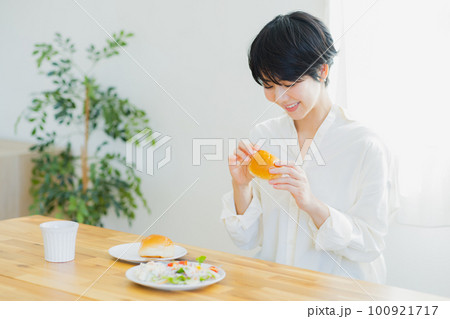 朝食を食べる若い女性　 100921717