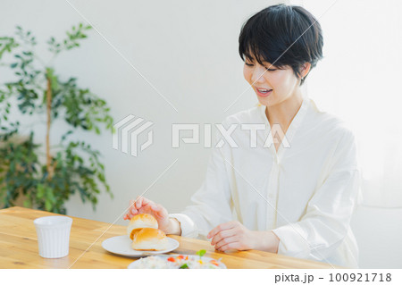 朝食を食べる若い女性　 100921718