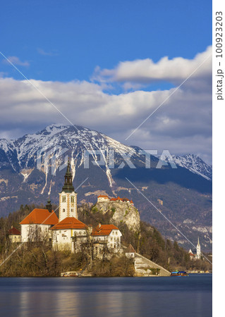 Bled lake with Bled catle, church and winter Julian Alps at background 100923203