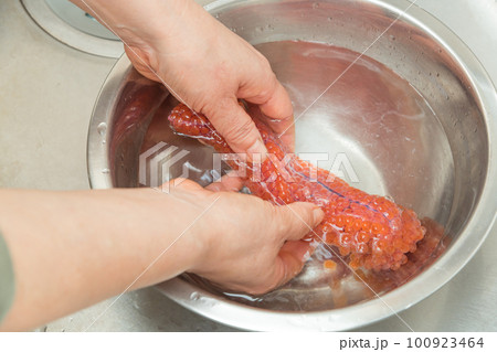 【イクラの醤油漬けを作るために、塩を入れたぬるま湯に生イクラを入れる】 【イクラの醤油漬けを作るために、塩を入れたぬるま湯に生イクラを入れる】 100923464