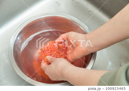 【イクラの醤油漬けを作るために、塩を入れたぬるま湯に生イクラを入れる】 【イクラの醤油漬けを作るために、塩を入れたぬるま湯に生イクラを入れる】 100923465