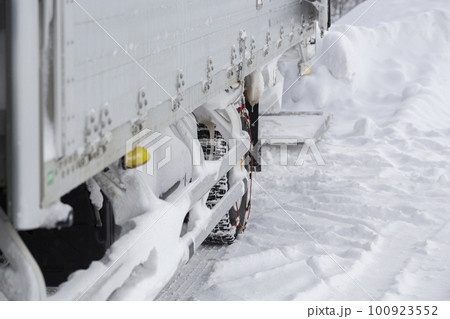 雪国のチェーンをつけたトラックのリアタイヤ 100923552