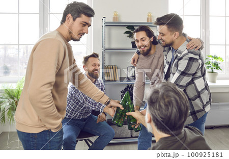 Group of happy male friends hanging out, drinking beer, clinking bottles, and having fun Group of happy male friends hanging out, drinking beer, clinking bottles, and having fun 100925181