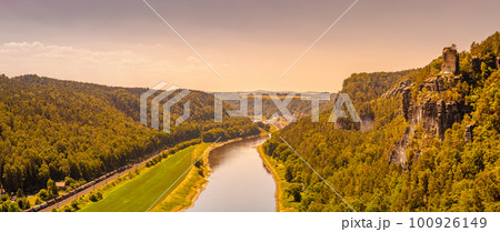 Panoramic birdview over monumental Bastei sandstone pillars at sunset near Kurort Rathen village in the national park Saxon Switzerland by Dresden and Elbe river, Saxony, Germany. Panoramic birdview over monumental Bastei sandstone pillars at sunset near Kurort Rathen village in the national park Saxon Switzerland by Dresden and Elbe river, Saxony, Germany. 100926149