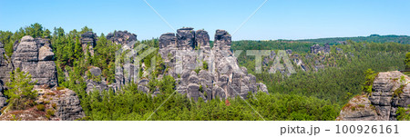 Panoramic view over monumental Bastei sandstone pillars and ancient bridge near Kurort Rathen village in the national park Saxon Switzerland by Dresden and Czechish border, Saxony, Germany. Panoramic view over monumental Bastei sandstone pillars and ancient bridge near Kurort Rathen village in the national park Saxon Switzerland by Dresden and Czechish border, Saxony, Germany. 100926161