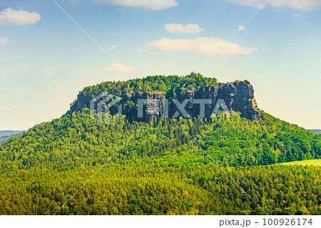 Panoramic view over monumental Lilienstein sandstone pillars, an iconic table like mount at sunset in the national park Saxon Switzerland by Dresden and Czechish border, Saxony, Germany. Panoramic view over monumental Lilienstein sandstone pillars, an iconic table like mount at sunset in the national park Saxon Switzerland by Dresden and Czechish border, Saxony, Germany. 100926174