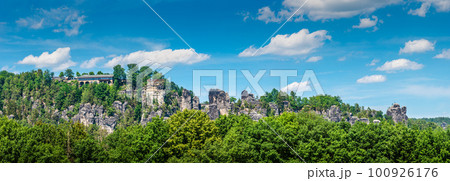 Panoramic view over monumental Bastei sandstone pillars and ancient bridge near Kurort Rathen village in the national park Saxon Switzerland by Dresden and Czechish border, Saxony, Germany. Panoramic view over monumental Bastei sandstone pillars and ancient bridge near Kurort Rathen village in the national park Saxon Switzerland by Dresden and Czechish border, Saxony, Germany. 100926176