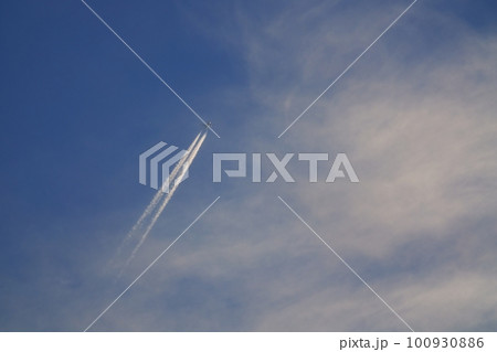 朝日に照らされるジェット機と飛行機雲・春・空のみ・230301am 100930886