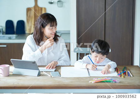 部屋で仕事をする母親と、お絵描きをする子供 部屋で仕事をする母親と、お絵描きをする子供 100933562