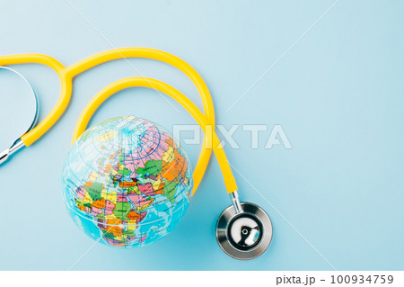World Health Day. Yellow doctor stethoscope and world globe isolated on blue background, Save world day, Green Earth, Healthcare and medical concept 100934759