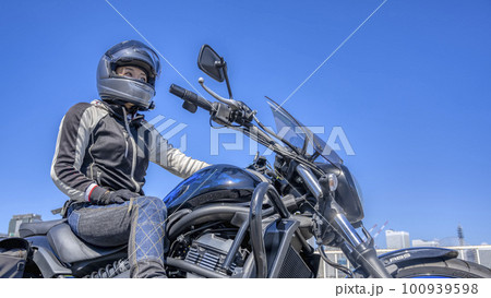 大型アメリカンバイクで横浜をツーリングする笑顔の女性ライダー 100939598