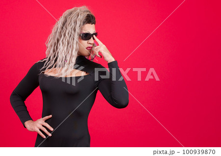 Transgender person wearing sunglasses posing with rebel attitude 100939870