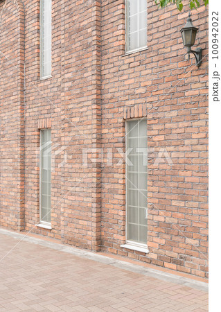 窓のあるレンガの壁 100942022