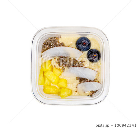 Smoothies with fresh fruits and nuts. Pineapple puree, banana. Pieces of coconut with blueberries. View from above. Smoothies with fresh fruits and nuts. Pineapple puree, banana. Pieces of coconut with blueberries. View from above. 100942341
