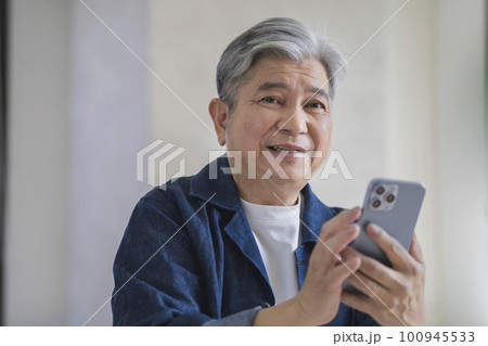 スマートフォンを持った60代の男性 スマートフォンを持った60代の男性 100945533