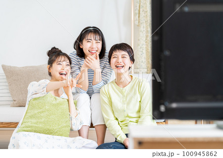 リビングでテレビを友達と見る若い女性 100945862
