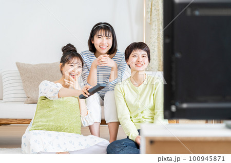 リビングでテレビを友達と見る若い女性 100945871