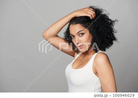 Mixed race african girl with natural curly black hair with hand on head Mixed race african girl with natural curly black hair with hand on head 100946029