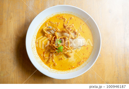 Thai Food, Khao Soi Kai, Thai spicy food, Thai spicy soup, Egg noodle in chicken curry on old wooden table background. 100946187