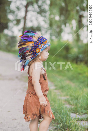 Cute baby dressed in traditional Native American costume 100946500