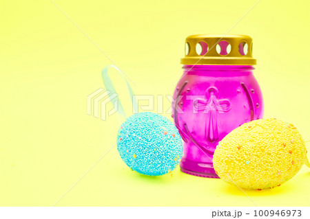 Church lamp candlestick with Easter eggs on a festive tender yellow background Church lamp candlestick with Easter eggs on a festive tender yellow background 100946973