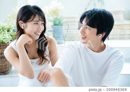 音楽を聴く若いカップル 100948369