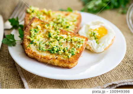 Fried croutons in batter with garlic and herbs in a plate. 100949366