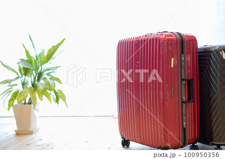 部屋に置いてある赤と黒の二つのスーツケース 100950356