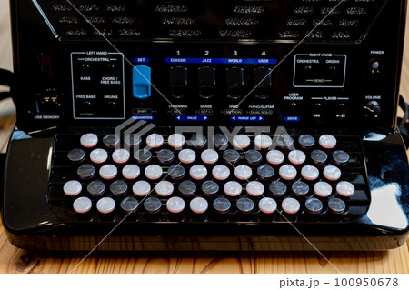 無垢板の床の上に置いてあるクロマチックボタン式アコーディオン 100950678