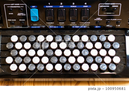 無垢板の床の上に置いてあるクロマチックボタン式アコーディオン 無垢板の床の上に置いてあるクロマチックボタン式アコーディオン 100950681