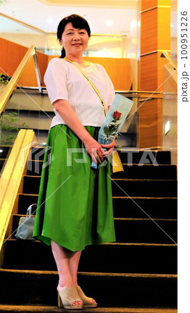 プレゼントされた花と一緒に会談で記念写真をする女性 プレゼントされた花と一緒に会談で記念写真をする女性 100951226