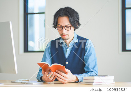 自宅の書斎で本を読む若い男性 自宅の書斎で本を読む若い男性 100952384