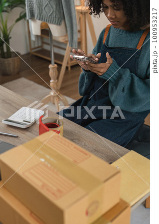 Entrepreneur, small business, SME, freelance woman working from home with lots of boxes on the side. Use smartphones and laptops for commercial monitoring. online marketing packaging box online sale 100953217
