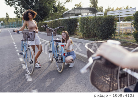Teenagers of different nationalities and appearance on bicycles ride along a city street Teenagers of different nationalities and appearance on bicycles ride along a city street 100954103