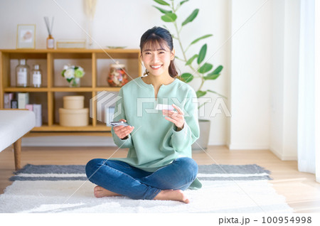 スマホを使ってキャッシュレス決済する若い女性 スマホを使ってキャッシュレス決済する若い女性 100954998