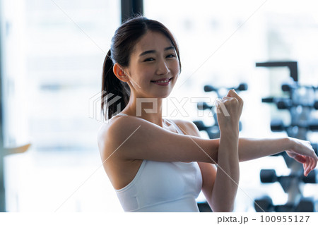 スポーツジムでトレーニングする若い女性 スポーツジムでトレーニングする若い女性 100955127