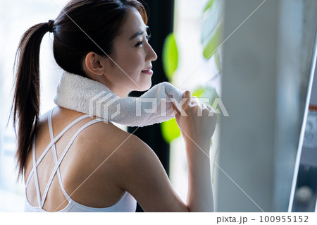 スポーツジムでトレーニングする若い女性 100955152