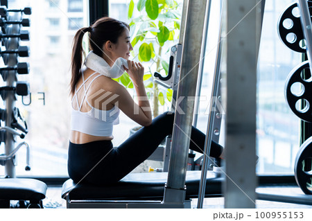 スポーツジムでトレーニングする若い女性 スポーツジムでトレーニングする若い女性 100955153