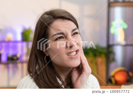 Woman touching cheek, closing eyes suffer from painful toothache, sensitive teeth, cavities at home 100957772